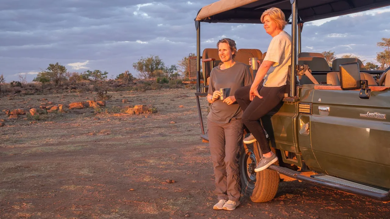 Vikki and Sian with a sundowner beside the game vehicle
